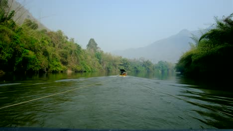 Ein-Boot,-Das-Im-Fluss-Fährt,-Mit-Einem-Dunstwald,-Der-Durch-Das-Abbrennen-Des-Landes-Durch-Bauern-Verursacht-Wird