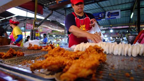 Brathähnchen-Ausstellung-Mit-Den-Verkäufern-In-Einer-Markthalle-In-Bangkok,-Thailand