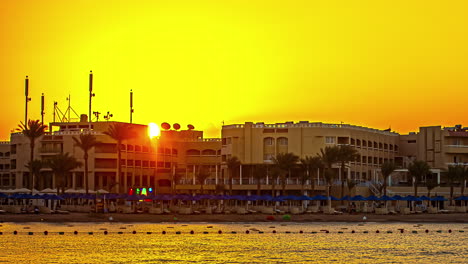 Amanecer-Time-lapse-En-La-Playa-De-Hurghada-Con-Palmeras,-Resorts-Y-Majestuosa-Silueta-De-Montaña-Al-Amanecer-Egipto,-áfrica