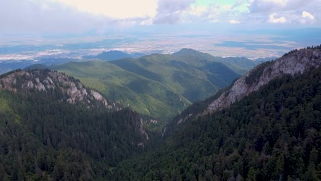Una-Impresionante-Vista-Aérea-De-Un-Exuberante-Bosque-Montañoso-Envuelto-En-Espesas-Nubes-Blancas,-Ubicado-En-Poiana-Brasov,-Rumania