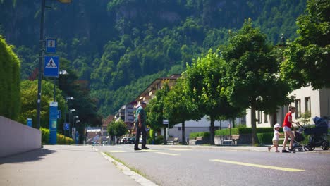 Mother,-Child,-Baby,-and-Elderly-Man-Crossing-The-Street---Hergiswil-Switzerland-Mountains-in-4K