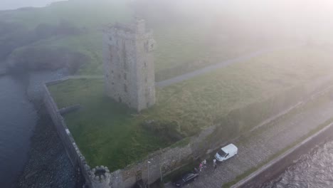 Drone-panning-Carrigaholt-Castle-and-Fishing-Harbour-in-a-drifting-sea-fog