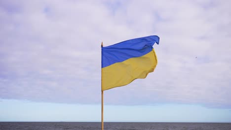 Die-Aufnahme-Einer-Ukrainischen-Flagge-Am-Stiel,-Die-Im-Wind-Flattert