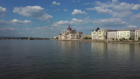 Toma-De-Un-Dron-Del-Edificio-Del-Parlamento-Húngaro-En-Budapest---Un-Dron-Se-Acerca-Mientras-Vuela-Justo-Por-Encima-Del-Río