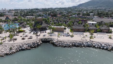 Aerial-trucking-shot-of-Taino-Bay-with-Puerto-Plata-and-luxury-apartments-with-swimming-pool
