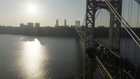 Aerial-view-flying-paralell-to-the-George-Washington-bridge,-sunset-above-Jersey,-USA---reverse,-drone-shot