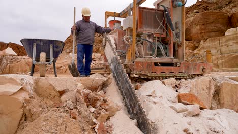 Motosierra-De-Piedra-Cortando-Bloques-De-Piedra-Caliza-En-Una-Cantera-Con-Operador,-Tiro-Medio