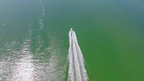 Weißes-Schnellboot,-Das-Auf-Smaragdgrünen-Gewässern-Fährt