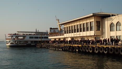 Menschenmenge,-Die-Im-Warmen-Abendlicht-Von-Der-Anlegestelle-Der-Fähre-In-Istanbul-Kadıköy-Aussteigt