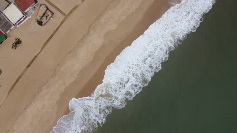 Drohnenaufnahme-Von-Praia-De-Faro---Drohne-Steigt-Aus-Der-Vogelperspektive-über-Den-Strand-Und-Die-Ankommenden-Wellen-Auf