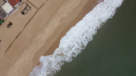 Tiro-De-Dron-De-Praia-De-Faro---Dron-Está-Ascendiendo-A-Vista-De-Pájaro-Sobre-La-Playa-Y-Las-Olas-Entrantes