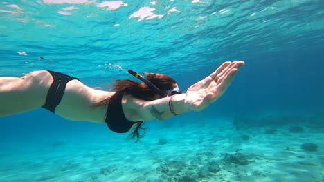 Slow-motion-shot-of-a-young-Caucasian-woman-diving-in-crystal-clear-blue-water