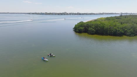 Kayakers-in-a-Florida-Bay-near-the-mangrove-tunnels-of-Lido-Key-with-boats-passing-in-the-background