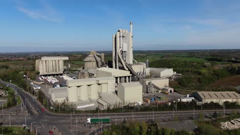 Cement-works-aerial-fly-by-view-from-right-to-left-with-moving-traffic-in-foreground