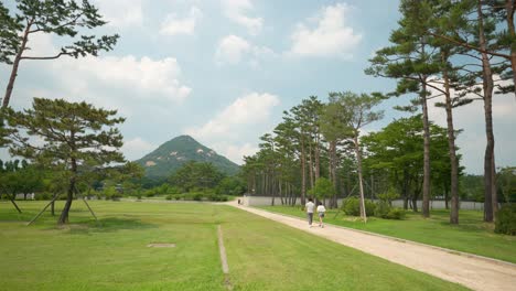 Majestätischer-Blick-Auf-Den-Bukhansan-Berg-In-Einiger-Entfernung-Vom-Gyeongbokgung-Palast-In-Seoul-Mit-Herumlaufenden-Menschen