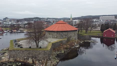 Aerial-slowly-rotating-around-front-of-Kristiansand-fortress-during-cloudy-morning---Norway