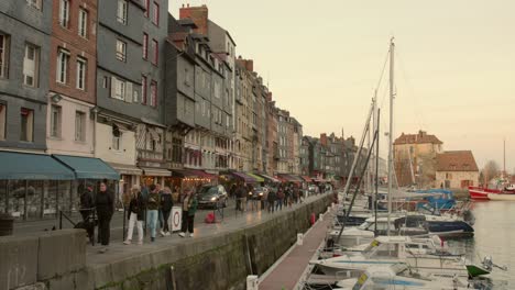 Tourists-And-Locals-Walking-In-Picturesque,-Historic-Harbour-Vieux-Bassin-In-The-Town-Of-Honfleur-In-France
