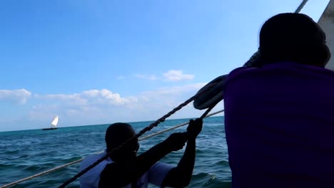 Tansanische-Segler-Genießen-Einen-Bootstag-Und-Versuchen,-Das-Segel-Im-Indischen-Ozean-Zu-öffnen