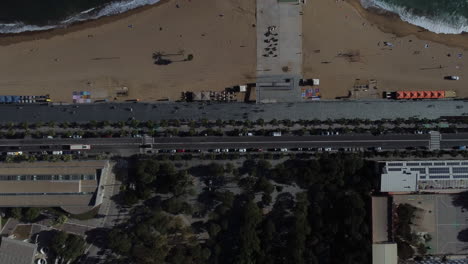 Drone-shot-of-Barcelona-beach---drone-is-ascending-in-birds-eye-view-over-a-street-near-the-promenade