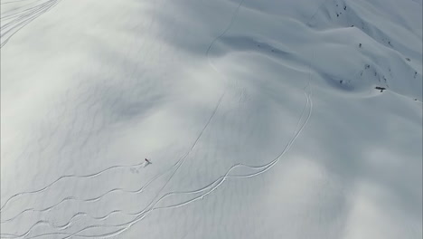 Einsame-Person,-Die-Auf-Einem-Weißen,-Abgelegenen-Berghang-Ski-Fährt,-Luftaufnahme