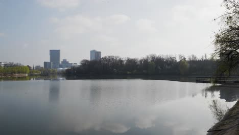 Establishing-Shot-Of-Public-Park-Lake-And-Office-Buildings-On-Background