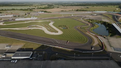 Establishing-aerial-view-over-Silverstone-wing-F1-paddock-and-British-motorsport-race-track-circuit