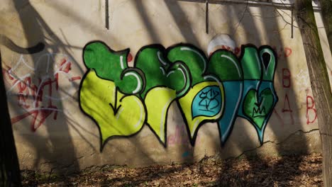 Arte-De-Graffiti-Verde-Y-Amarillo-En-El-Parque-En-La-Pared