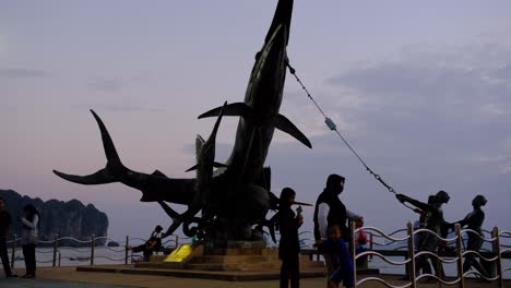 Estatua-De-Pez-Espada-En-La-Playa-De-Ao-Nang,-Krabi-Tailandia-Con-Gente