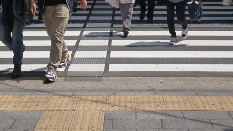 Vista-Panorámica-De-La-Vista-Inferior-Hacia-El-Cruce-De-La-Carretera-Mientras-La-Gente-Cruza-La-Carretera-Durante-El-Día-De-Verano-En-Shibuya,-Tokio,-Japón