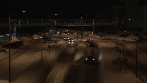 Winter-city-night-traffic-drive-roundabout-on-snowy-Helsinki-street