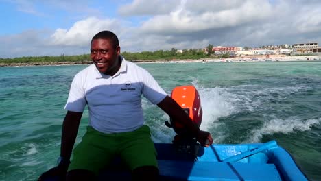 Fröhliche-Tansanische-Reiseführer-Begrüßen-Sie,-Während-Sie-Mit-Einem-Motorisierten-Faserboot-Durch-Den-Indischen-Ozean-Navigieren