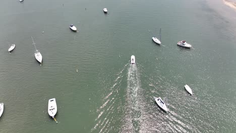 An-aerial-view-of-the-Northport-Marina-on-Long-island,-NY-with-several-anchored-boats-on-a-sunny-day