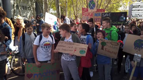 A-group-of-highschool-kids-sing-protest-songs-and-holding-posters-and-signs-on-a-Fridays-for-Future-demonstration-in-Cologne,-Germany