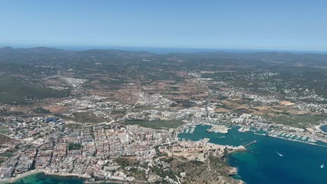 Aerial-view-from-a-jet-cockpit-of-Ibiza-city-and-harbor-in-a-summer-afternoon
