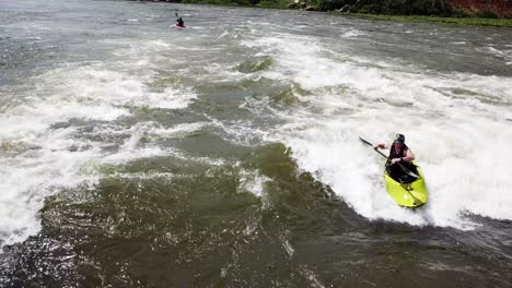 Aerial-view-of-a-kayaker-descending-and-pirouetting-through-the-swirling-waters-of-the-Nile-River-in-Jinja,-Uganda