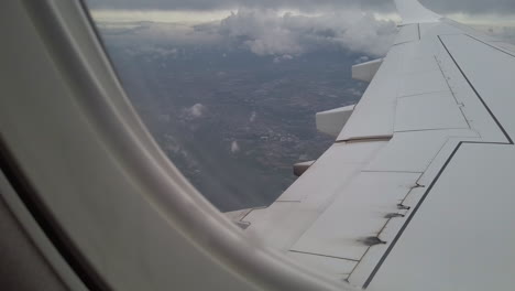 Blurred-landscape-through-the-window-of-an-airplane-by-a-gray-weather