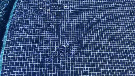 Ein-Entspannendes-Bild-Von-Wasser,-Das-Sich-über-Einen-Blauen-Mosaikfliesenhintergrund-Bewegt