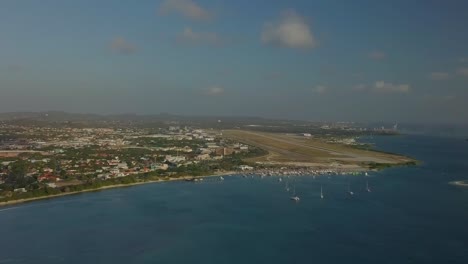 Aerial-pan-view-of-the-beautiful-water,-island-and-city-Oranjestad-of-Aruba