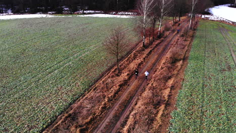 Colorful-dressed-person-run-between-brown-fields-on-ground-path