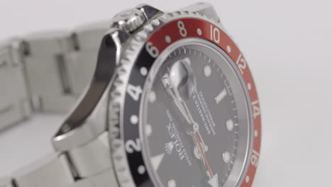 Close-up-footage-of-a-luxury-Rolex-watch-rotating-on-a-white-turntable-display