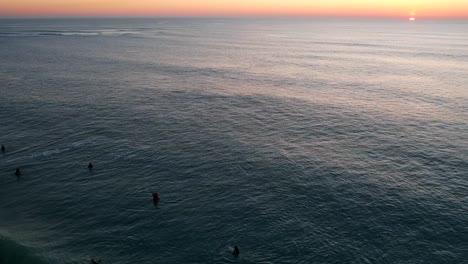 Surfers-waiting-to-catch-a-wave-in-the-atlantic-ocean-during-sunset-in-Cadiz,-Spain