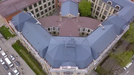 Luftaufnahme-Eines-Gebäudes-In-Der-Stadt-Cluj-Mit-Autos,-Die-Eine-Straße-Vor-Dem-Gebäude-überqueren,-Cluj,-Rumänien