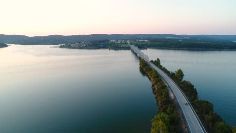 Aerial-flight-over-a-bridge-and-highway-that-runs-through-an-Ozark-lake