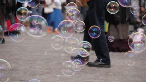 Bubbles-falling-on-the-ground-at-Dam-Square,-Amsterdam---180-fps-slow-motion