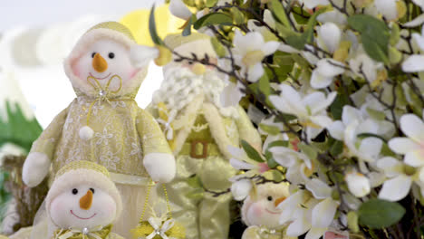 Cute-snowmen-family-dolls-and-Santa-Clauss-near-flowers