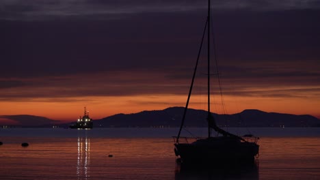 Langsamer-Zoom-Auf-Ein-Vor-Anker-Liegendes-Segelboot-Bei-Sonnenuntergang