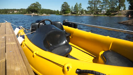 A-small-yellow-powerboat-tied-to-the-pier-on-a-lake-from-the-front,-MEDIUM-SHOT
