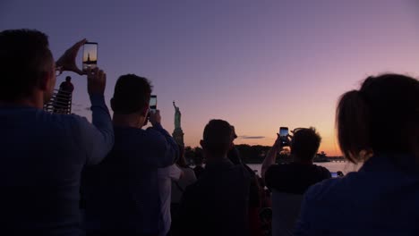 Foto-De-Silueta-De-Turistas-Tomando-Fotos-De-La-Estatua-De-La-Libertad-Desde-Un-Barco-Al-Atardecer