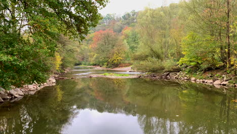 Ein-Ruhiger-Fluss-Mit-Bäumen-Auf-Beiden-Seiten-Im-Herbst