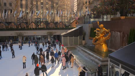 árbol-De-Navidad-Del-Centro-Rockefeller,-Estatua-De-Prometeo-En-La-Fuente-Y-Gente-Patinando-En-La-Pista-De-Hielo-Durante-La-Puesta-De-Sol-En-Nueva-York,-Estados-Unidos